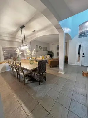 a dining room and living room with a table and chairs at Emerald Island Private Pool Home near Disney in Kissimmee