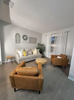 a living room with a couch and chairs and a table at Emerald Island Private Pool Home near Disney in Kissimmee