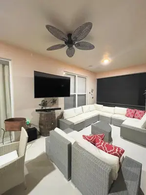 a living room with white furniture and a ceiling fan at Emerald Island Private Pool Home near Disney in Kissimmee