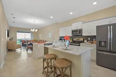 a kitchen with white cabinets and a kitchen island with stools at 3131 Paradox Circle, Unit 404 #838 apts in Kissimmee