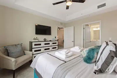 a bedroom with a bed and a chair and a television at Resort Life at Storey Lake by Shine Villas, #702 apts in Kissimmee