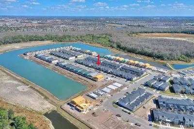 an aerial view of a building complex next to a body of water at Blue Beach at Storey Lake by Shine Villas #400 townhouse in Kissimmee