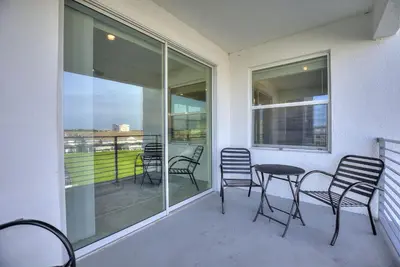 a balcony with chairs and a table and windows at Fireworks Night -Storey Lake by Shine Villas 709 apts in Kissimmee
