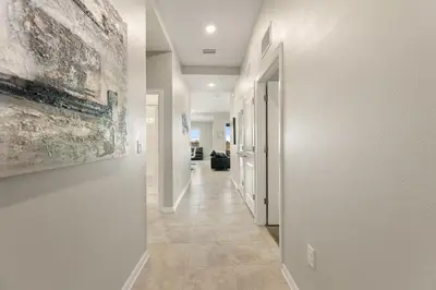 a hallway with white walls and a tile floor at Fireworks Night -Storey Lake by Shine Villas 709 apts in Kissimmee