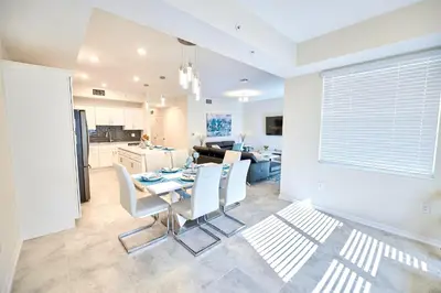 a kitchen and dining room with a table and chairs at Vacation Meadows - Storey Lake by Shine Villas 710 apts in Kissimmee
