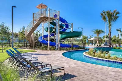 a water slide at a resort with chairs and a pool at Vacation Meadows - Storey Lake by Shine Villas 710 apts in Kissimmee
