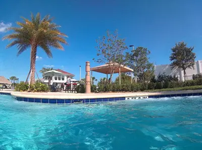 a swimming pool with blue water in front of a house at Vacation Meadows - Storey Lake by Shine Villas 710 apts in Kissimmee