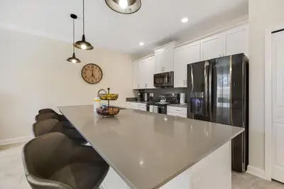 a kitchen with a large counter and a refrigerator at Barefoot Breeze - Storey Lake by Shine Villas #833 townhouse in Kissimmee
