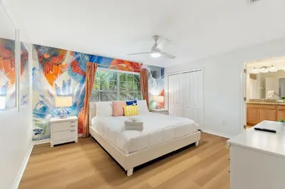 a bedroom with a bed and a painting on the wall at Haven Station at Storey Lake by Shine Villas townhouse in Kissimmee