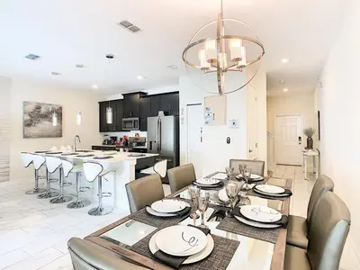 a dining room and kitchen with a table and chairs at Happy Haven at Storey Lake Resort by Shine Villas condo in Kissimmee