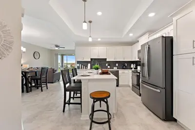 a kitchen with white cabinets and a black refrigerator at Triple Header Storey Lake by Shine Villas apts in Kissimmee