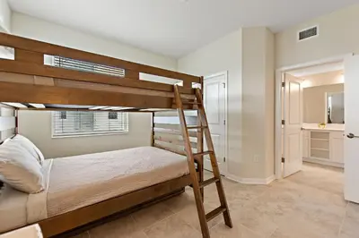 a bedroom with bunk beds and a bathroom at Triple Header Storey Lake by Shine Villas apts in Kissimmee