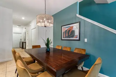 a dining room with a wooden table and chairs at Lazy Life at Storey Lake by Shine Villas #901 condo in Kissimmee