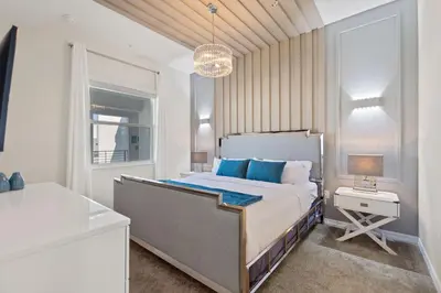 a bedroom with a large bed with blue pillows at Duck House at Storey Lake by Shine Villas #992 apts in Kissimmee