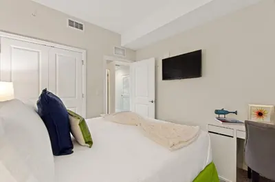 a white bedroom with a bed and a flat screen tv at Tranquility at Storey Lake by Shine Villas #828 apts in Kissimmee
