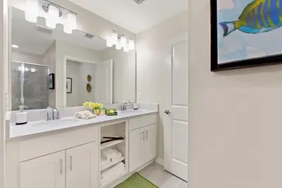 a bathroom with a sink and a large mirror at Tranquility at Storey Lake by Shine Villas #828 apts in Kissimmee