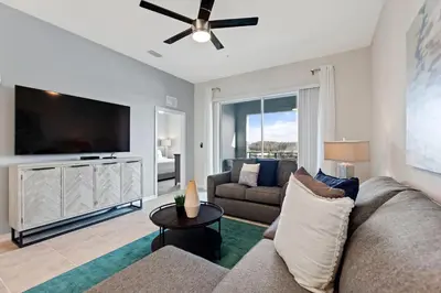 a living room with a couch and a flat screen tv at Edgewater Escape at Storey Lake by Shine Villas apts in Kissimmee
