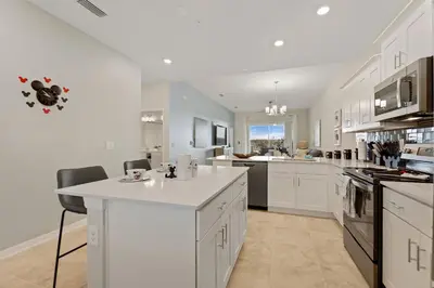 a kitchen with white cabinets and a white counter top at Edgewater Escape at Storey Lake by Shine Villas apts in Kissimmee