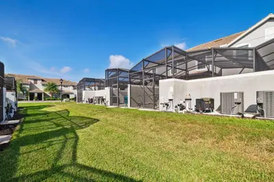 a building with a grassy yard in front of it at Star Hideaway at Storey Lake by Shine Villas townhouse in Kissimmee