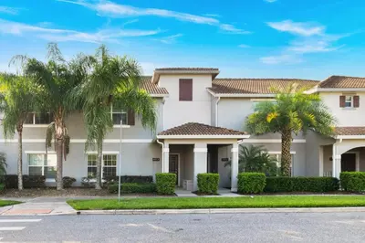a house with palm trees in front of it at Star Hideaway at Storey Lake by Shine Villas townhouse in Kissimmee
