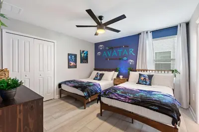a bedroom with two beds and a ceiling fan at Water Kingdom Storey Lake by Shine Villas! #525 home in Kissimmee