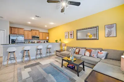 a living room with a couch and a bar at 5 Mi to Disney Paradise Palms Retreat with Lanai in Kissimmee