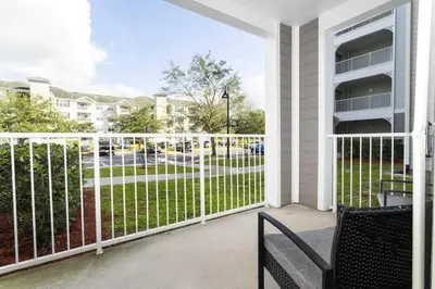 a balcony with a white fence and a chair at Your Orlando stay 15 min to Disney - DVH01 in Kissimmee