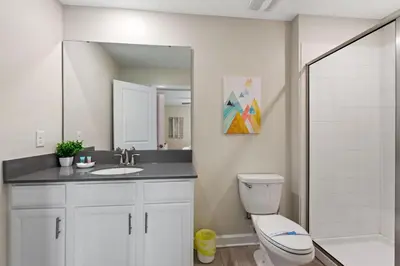 a bathroom with a sink and a toilet and a mirror at Treat Retreat Storey Lake by Shine Villas #418 villa in Kissimmee