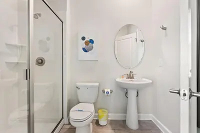 a bathroom with a toilet and a sink and a mirror at Treat Retreat Storey Lake by Shine Villas #418 villa in Kissimmee