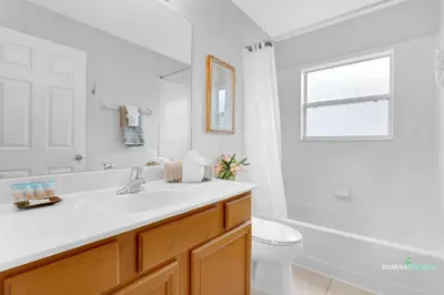 a white bathroom with a sink and a toilet at Private Pool, Spa Tub, Themed Rooms, Resort Amenities in Kissimmee