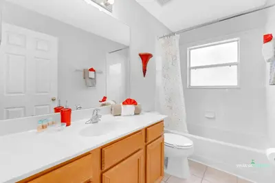 a bathroom with a sink and a toilet and a window at Private Pool, Spa Tub, Themed Rooms, Resort Amenities in Kissimmee