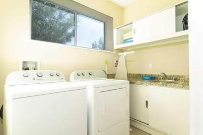 a white washer and dryer in a kitchen with a window at Gorgeous 4 Bd Close to Disney @ Magic Village 3114 in Orlando