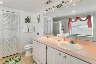 a bathroom with two sinks and a toilet and a mirror at Pool and Hot Tub Home 17 Mi to Epic Universe! in Kissimmee