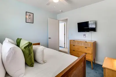 a bedroom with a bed with a television and a dresser at Pool and Hot Tub Home 17 Mi to Epic Universe! in Kissimmee