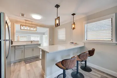 a kitchen with a counter and two bar stools at Apopka Home with Yard and Grill Near Wekiwa Springs! in Apopka