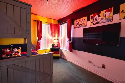 a room with a bedroom with a tv and a door at Laguna Bay 2 Bedroom Condo Resort Pool 8 Miles to Disney in Kissimmee