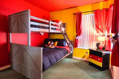 a bedroom with a bunk bed and a red wall at Laguna Bay 2 Bedroom Condo Resort Pool 8 Miles to Disney in Kissimmee