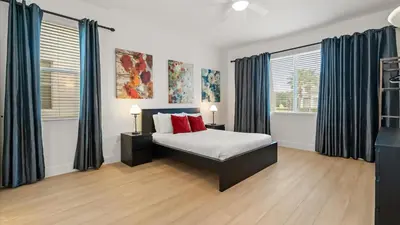 a bedroom with a bed and two windows at 6BR Luxury Home with Private Pool and BBQ in Kissimmee
