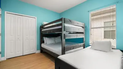 a bedroom with two bunk beds and a blue wall at 6BR Luxury Home with Private Pool and BBQ in Kissimmee