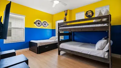 two bunk beds in a room with blue and yellow walls at 6BR Luxury Home with Private Pool and BBQ in Kissimmee