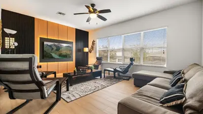 a living room with a couch and a ceiling fan at 6BR Luxury Home with Private Pool and BBQ in Kissimmee