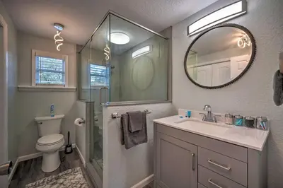 a bathroom with a toilet and a sink and a mirror at Apopka Getaway with Yard and Covered Patio in Apopka