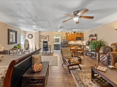 a living room with a couch and a ceiling fan at College Park-Orlando 5Star Villa Oasis - Home Away From Home - QUIET Neighborhood-PRIVATE Botanical Courtyard - mins from EOLA,DT, Winter Park - Free Parking & EV Plug In in Orlando