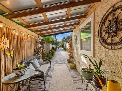 a patio with chairs and a couch and a table at College Park-Orlando 5Star Villa Oasis - Home Away From Home - QUIET Neighborhood-PRIVATE Botanical Courtyard - mins from EOLA,DT, Winter Park - Free Parking & EV Plug In in Orlando