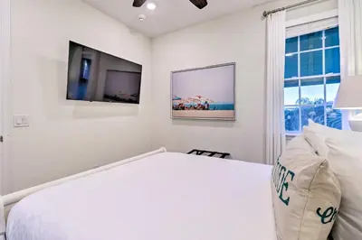 a white bedroom with a bed and a tv at Tropical Cottage with Hot Tub Near Disney! in Orlando