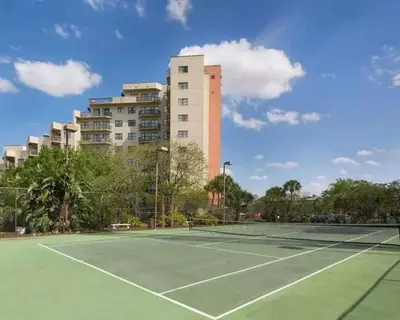 a tennis court with a building in the background at 3509 Luxury Location and Location in Orlando