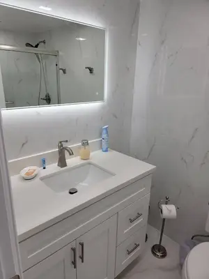a white bathroom with a sink and a mirror at 3509 Luxury Location and Location in Orlando