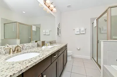 a bathroom with two sinks and a shower and a toilet at Vibrant Home Near Disney With Private Pool, Waterpark And Resort Acces At Encore Resorts Reunion - 221Fl in Kissimmee