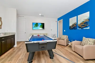 a pool table in a living room with blue walls at Vibrant Home Near Disney With Private Pool, Waterpark And Resort Acces At Encore Resorts Reunion - 221Fl in Kissimmee
