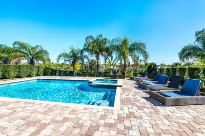 a swimming pool with lounge chairs and palm trees at Vibrant Home Near Disney With Private Pool, Waterpark And Resort Acces At Encore Resorts Reunion - 221Fl in Kissimmee